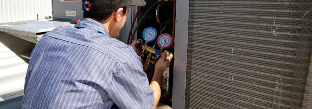 HVAC technician servicing a condenser unit in Austin
